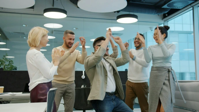Diverse group of colleagues celebrating success in office